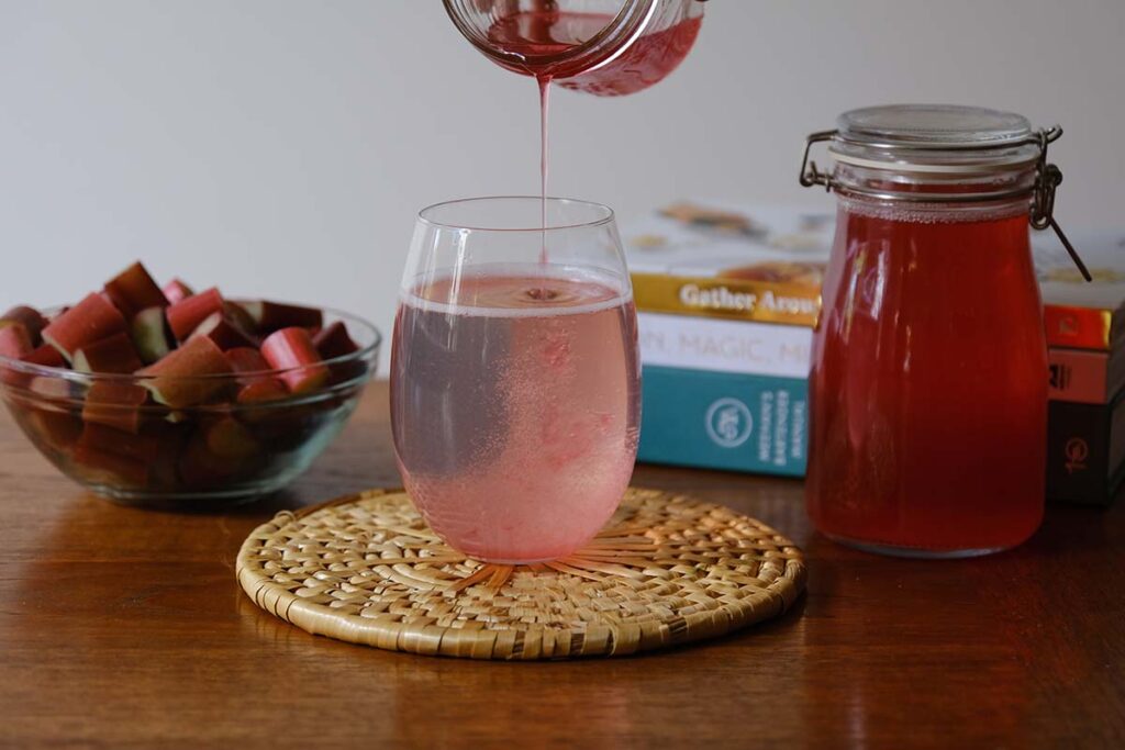 Pouring rhubarb syrup into sparking water