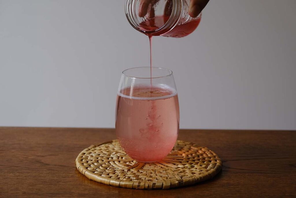 Pouring rhubarb syrup into sparking water