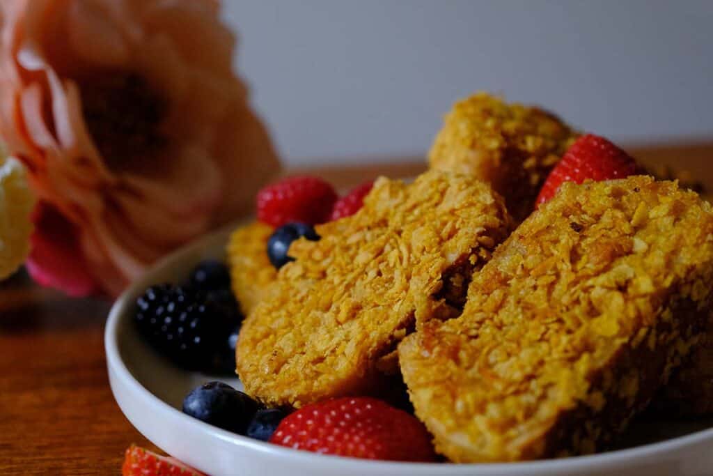Golden brown French toast recipe with crunchy cornflake crust and colorful berries, perfect for weekend breakfast.