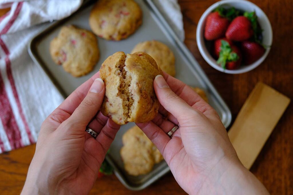 Hands holidng a strawberry shortcake cookie