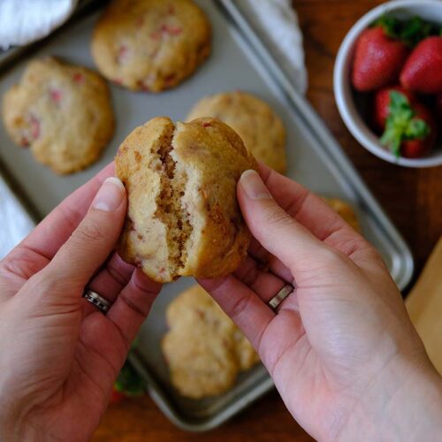 Hands holidng a strawberry shortcake cookie