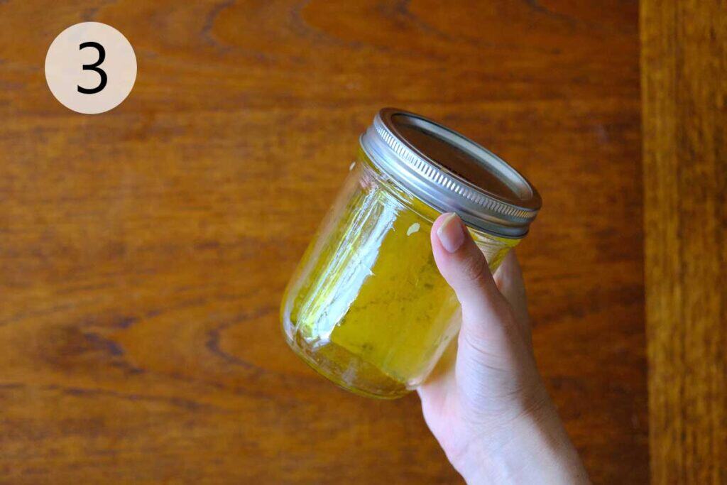 Mason jar with salad dressing ingredients being shaken