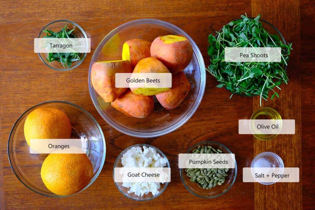 Ingredients to make the golden beet salal including beets, oranges, pea shoots, goats cheese, and herbs.