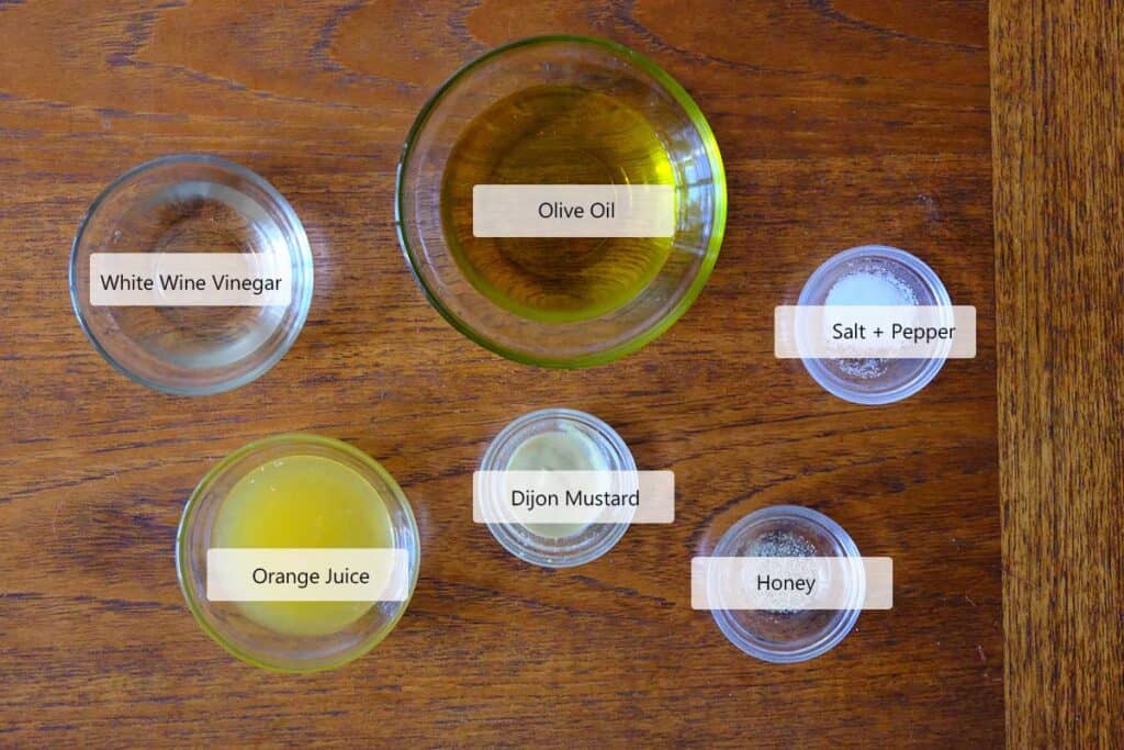 Ingredients to make the golden beet salad dressing including olive oil, white wine vinegar, dijon mustard, orange juice and honey