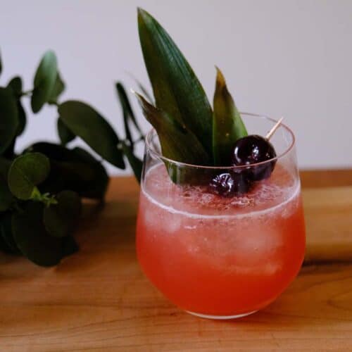 Tropical Shark's Tooth Cocktail in a clear glass with bold garnish, crushed ice, and a float of Jamaican rum.