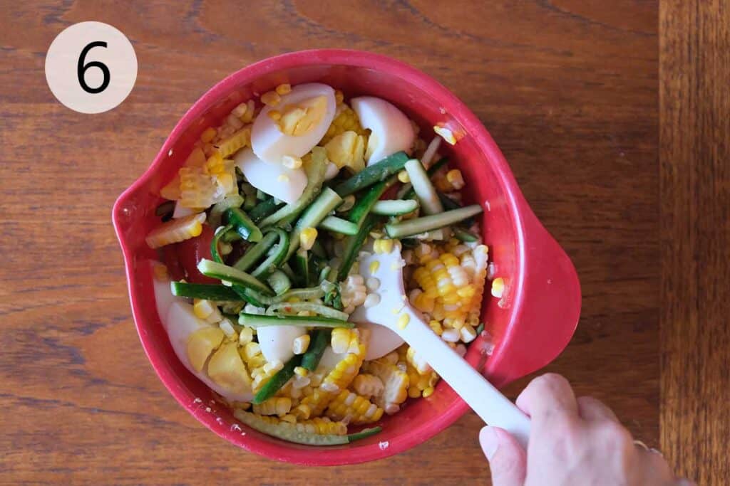 Folding grilled corn and salted eggs into Thai Corn Salad.