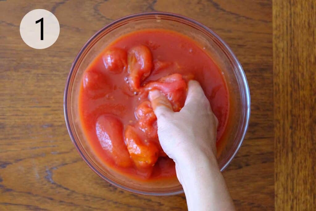Hand-crushing San Marzano tomatoes for an authentic Neapolitan pizza sauce recipe, step-by-step homemade pizza sauce.