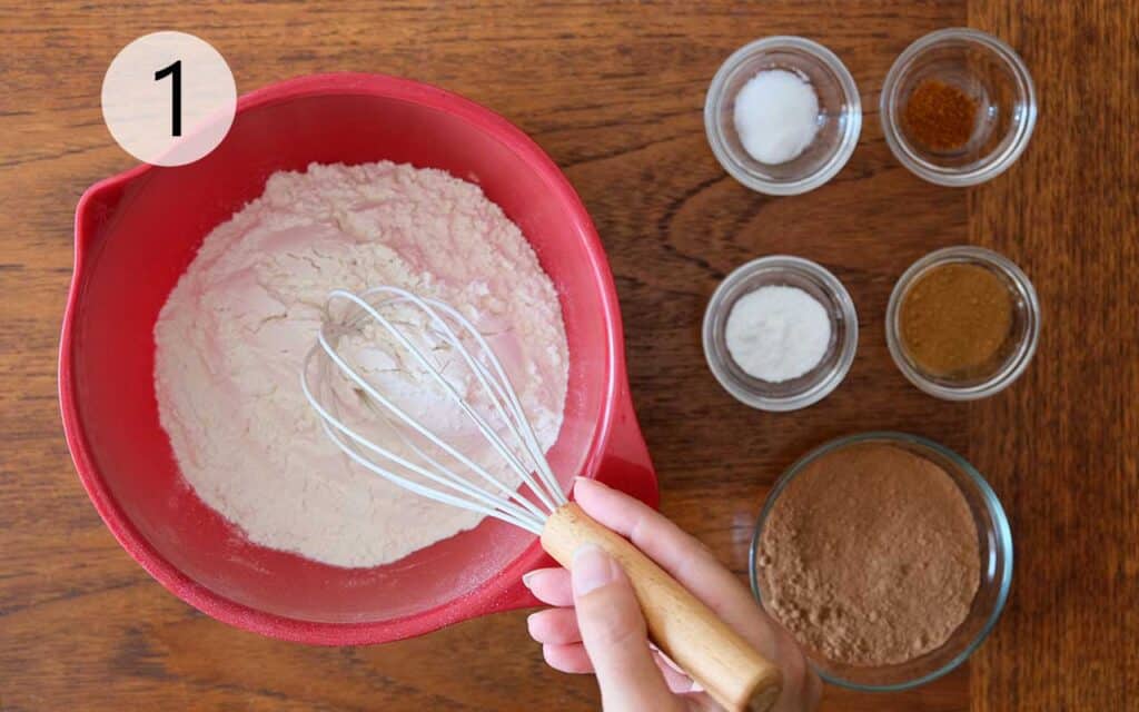Mixing flour, cocoa powder, cinnamon, cayenne, and baking soda in a bowl for Mexican Chocolate Cookies recipe.