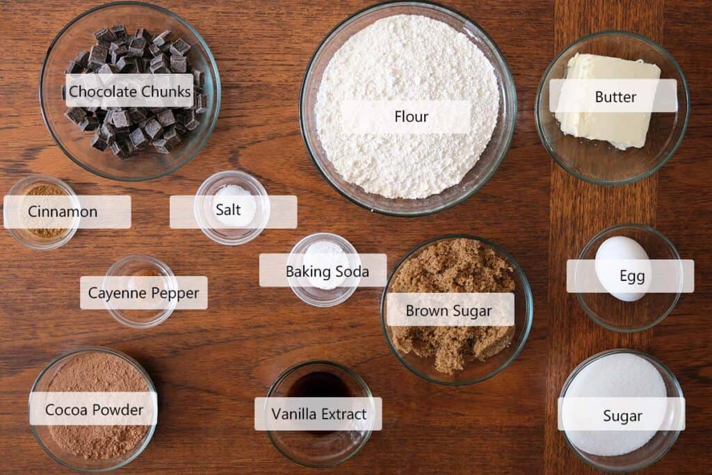 Ingredients for Mexican Chocolate Cookies recipe including cocoa powder, cinnamon, cayenne, brown sugar, butter, eggs, and dark chocolate chunks.