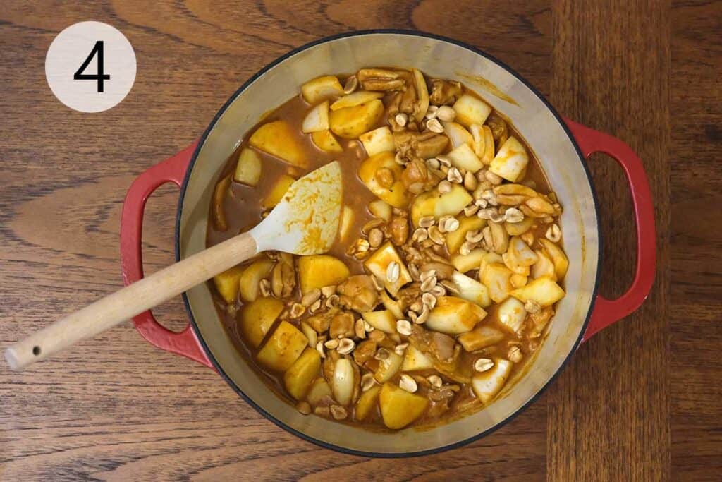 Adding yellow potatoes, onion, and roasted peanuts to simmer in the Chicken Massaman Curry Recipe for tender, rich flavor.
