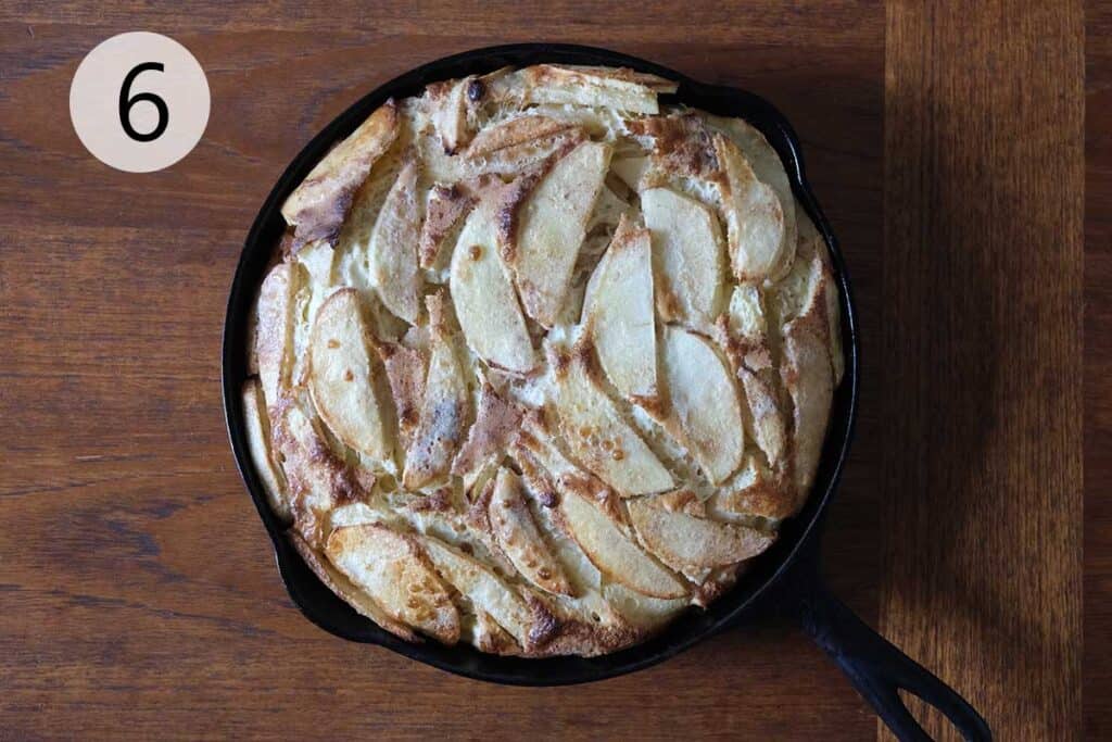 Freshly baked German Apple Pancake in a cast iron skillet, golden brown and puffed with tender cinnamon apples, perfect for a cozy weekend brunch.