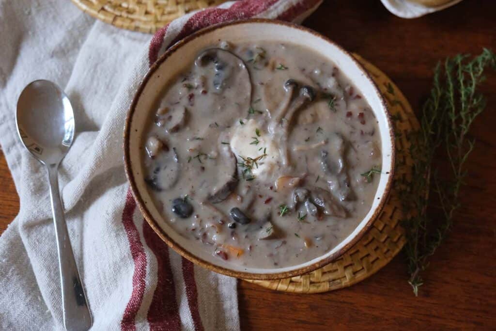 Creamy wild mushroom soup recipe in rustic bowls, showing rich, velvety broth and hearty mushroom pieces.