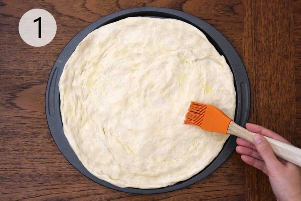 Homemade pizza dough stretched onto a pizza tray.
