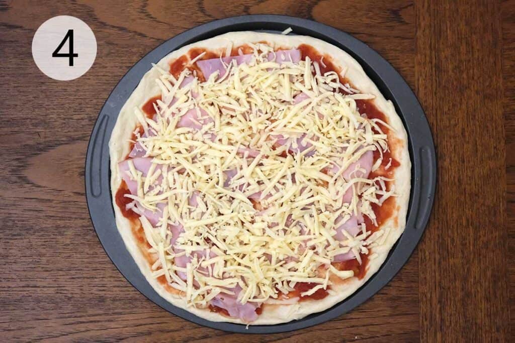Adding a generous layer of shredded mozzarella over the ham for the cheesy topping on Hawaiian pizza.