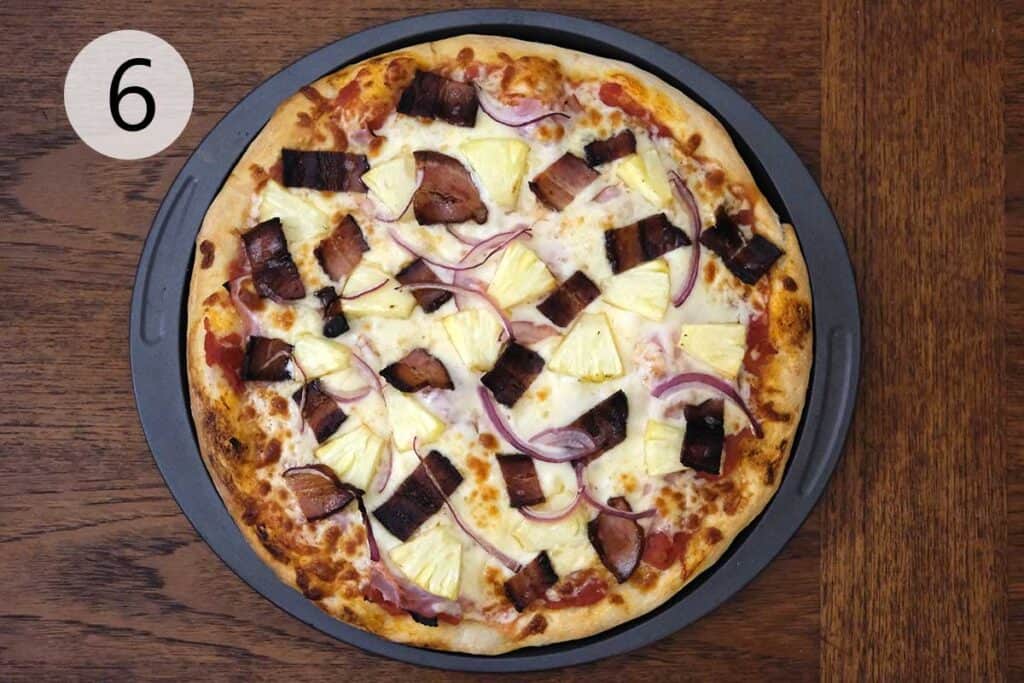 Finished Hawaiian pizza topped with bacon pineapple and red onion.