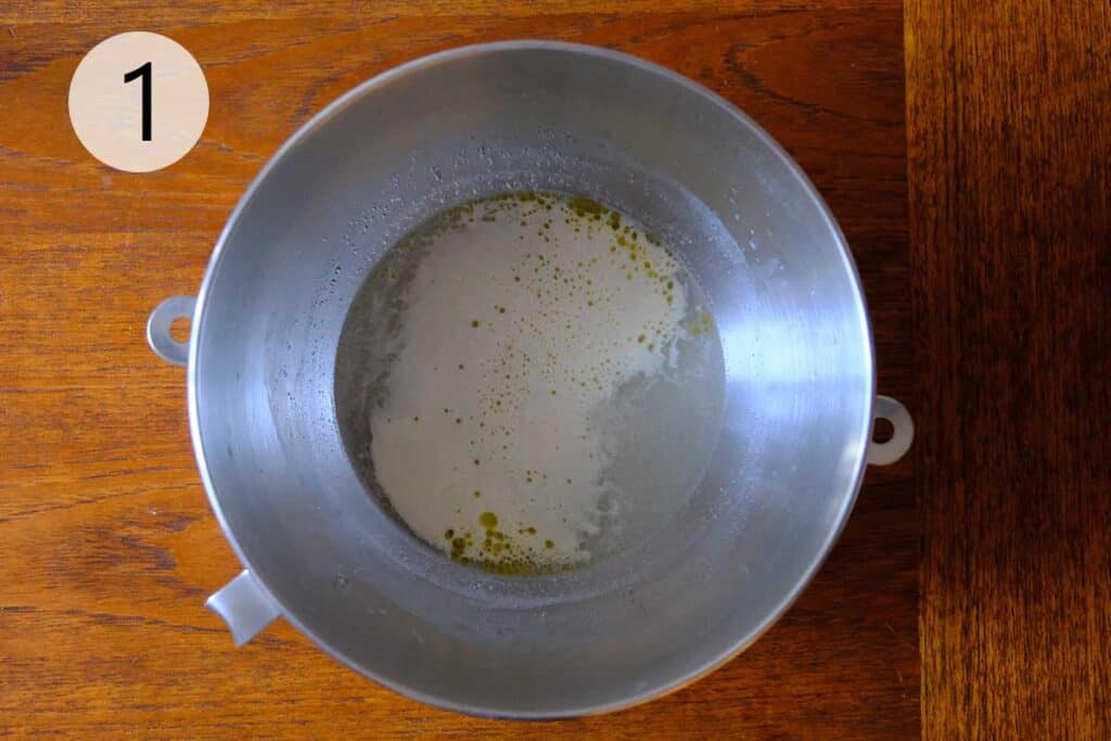 Activating yeast in warm water with sugar for a thin crust pizza dough recipe, the first step in making homemade pizza dough.