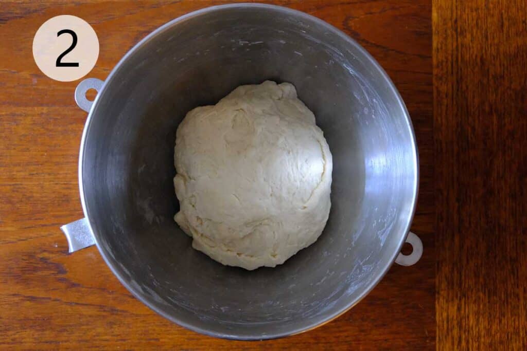 Thin crust pizza dough resting in a lightly oiled bowl during the first rise.