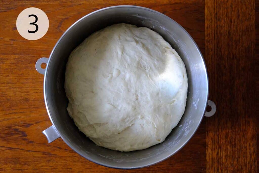 Thin crust pizza dough resting in a lightly oiled bowl during the first rise, showing airy and doubled dough for homemade pizza.