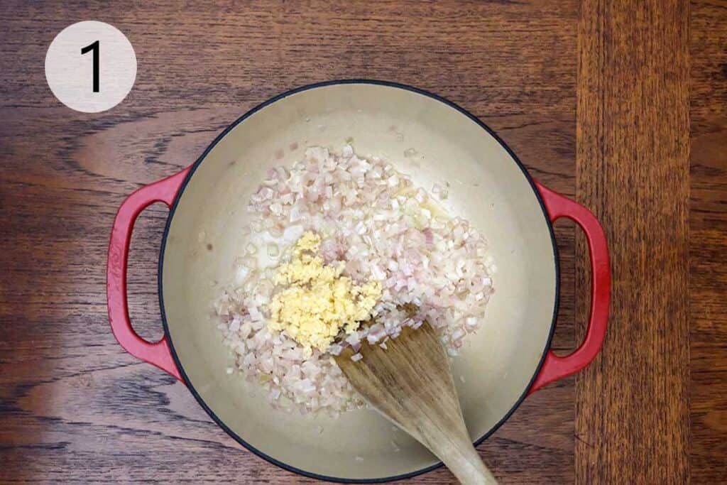 Butter melting in a large pot with minced shallots and garlic being sautéed for the wild mushroom soup base.