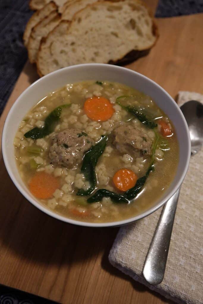 a bowl of homemade turkey meatball soup with sliced bread