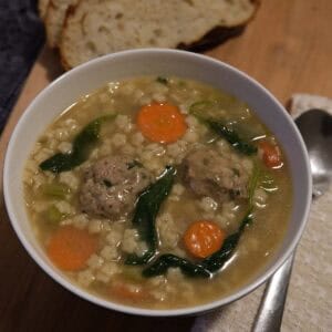 a bowl of homemade turkey meatball soup with sliced bread