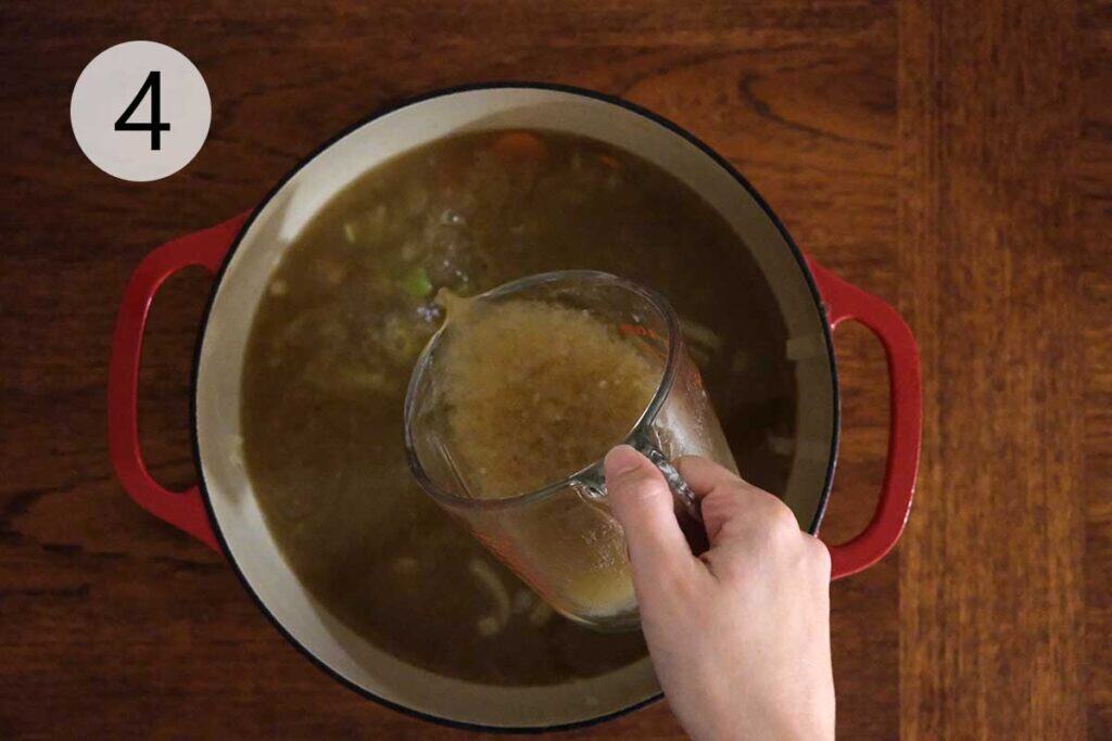 Turkey stock and small pasta simmering in a pot to make Turkey Meatball Soup Recipe.