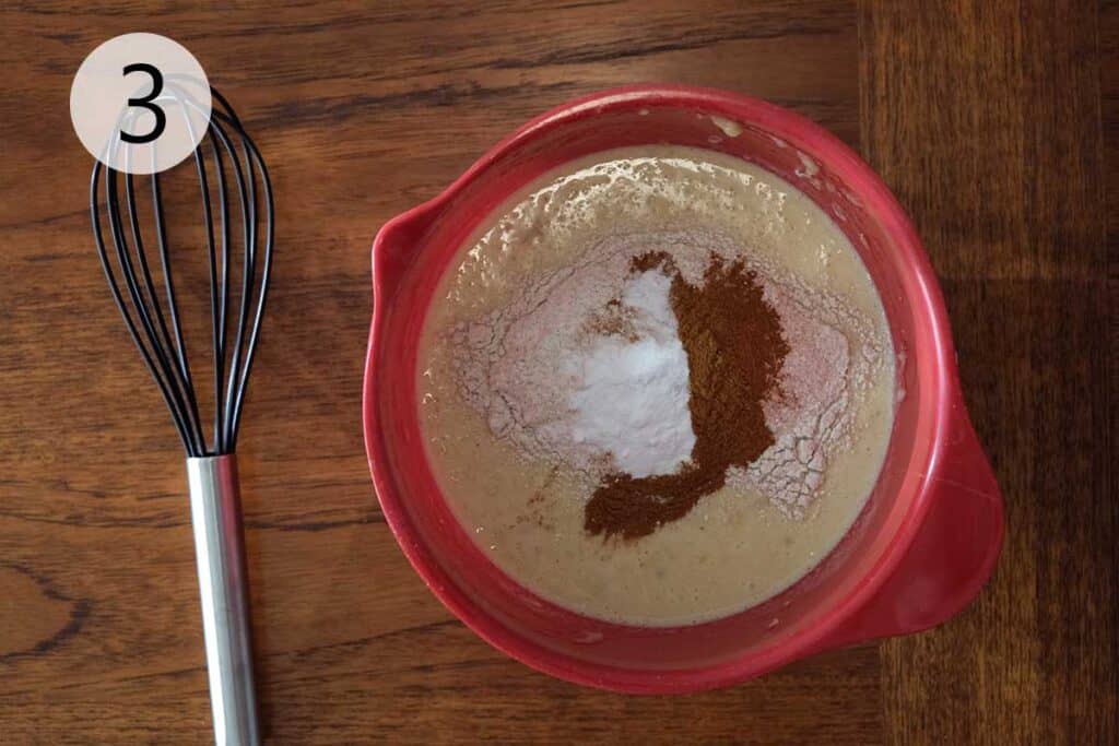 Whole wheat flour, cinnamon, hemp hearts, and baking soda being mixed into banana pancake batter.