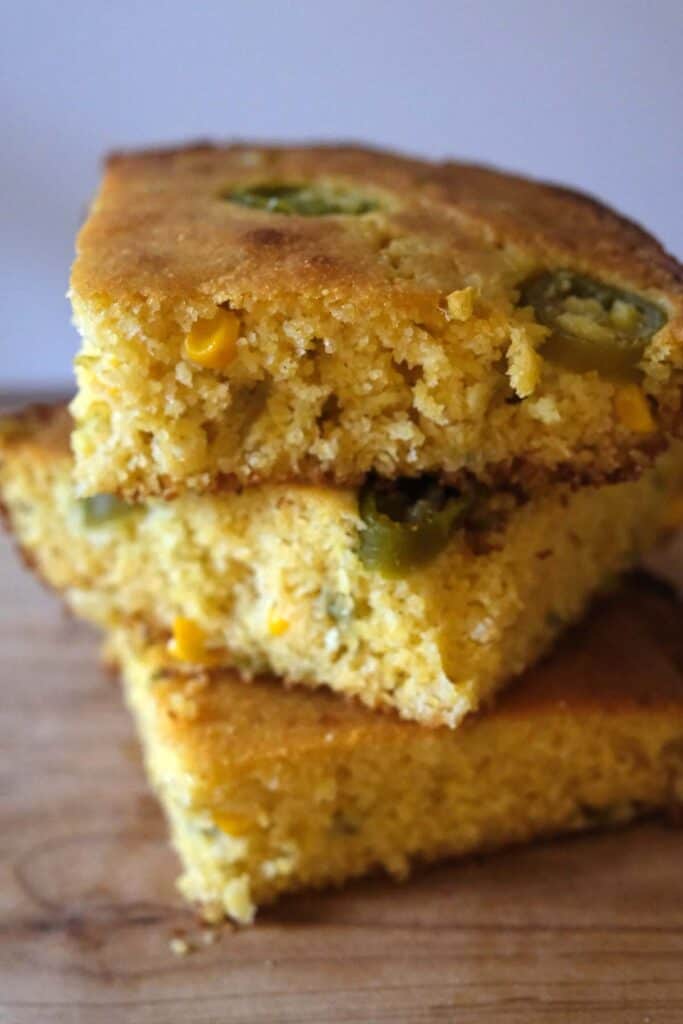 Stacked slices of skillet jalapeño cornbread with crispy edges and tender crumb baked in a cast iron skillet