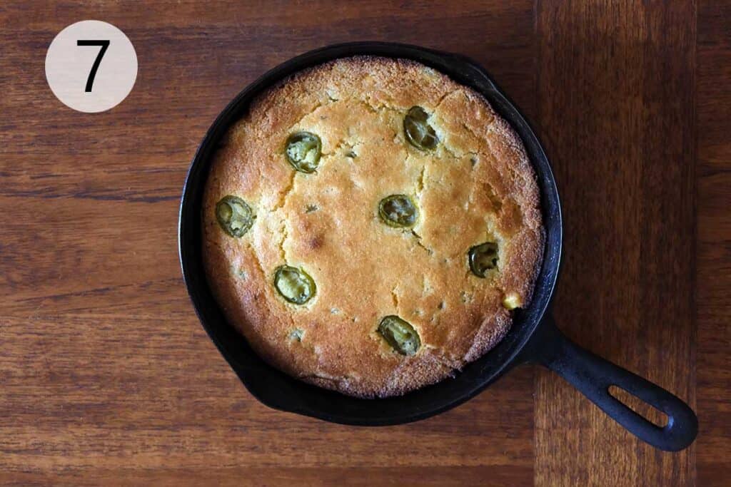 resh baked skillet jalapeño cornbread cooling in cast iron skillet before slicing