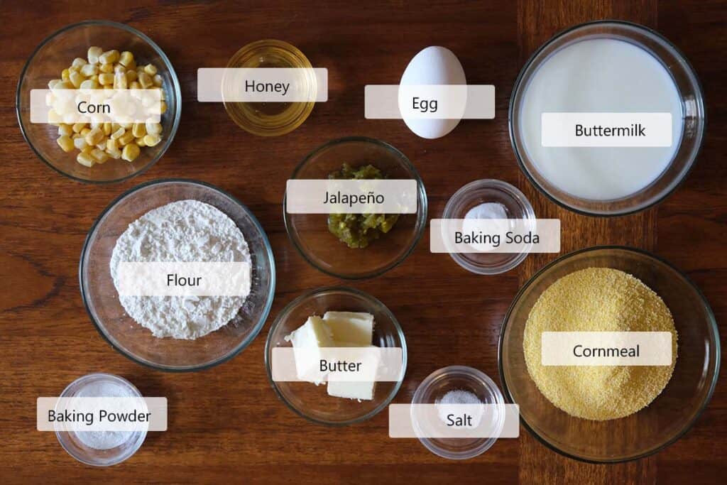 Ingredients for skillet jalapeño cornbread including cornmeal, flour, jalapeños, corn, honey, buttermilk, egg, and butter