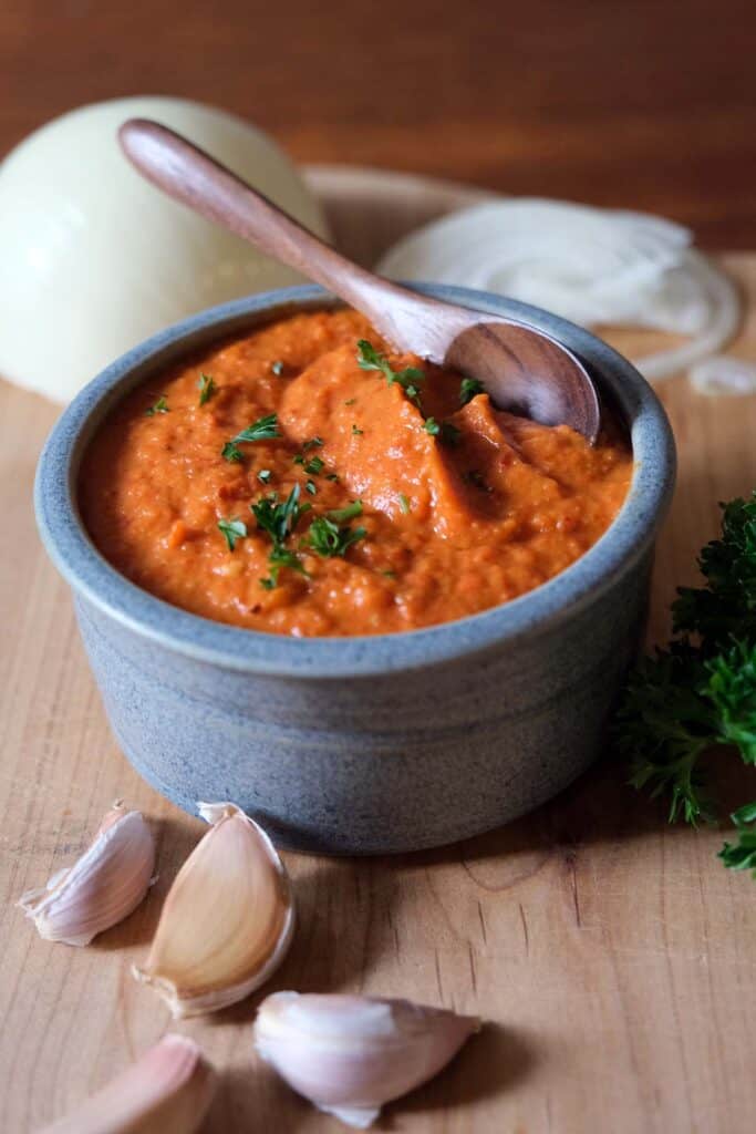 Ajvar recipe traditional Serbian roasted red pepper spread served in a bowl with garlic and parsley