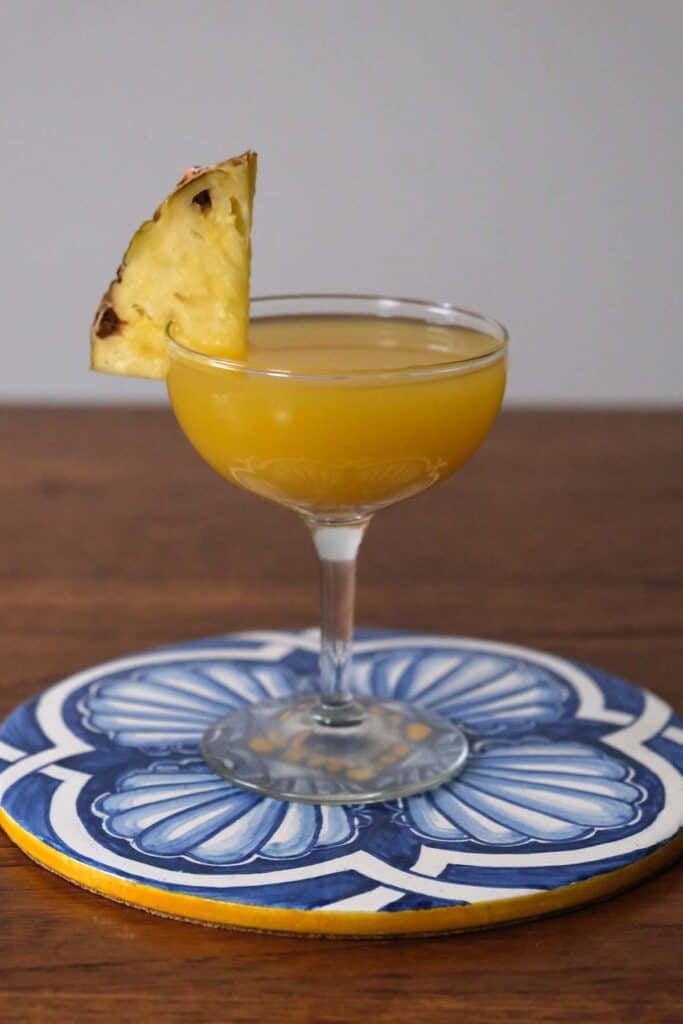 Fruity coconut rum cocktail with pineapple juice and lime in coupe glasses